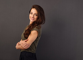 Beautiful natural toothy smiling woman with long brown healthy hair style with folded arms. Healthy lifestyle and success business. Closeup portrait on grey background