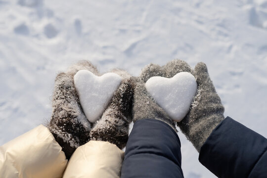 Unrecognizable kids with heart shaped snowball