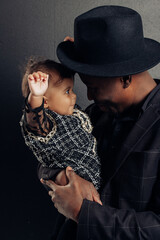 Young african man has a fun and plays with his baby daughter from interracial marriage.