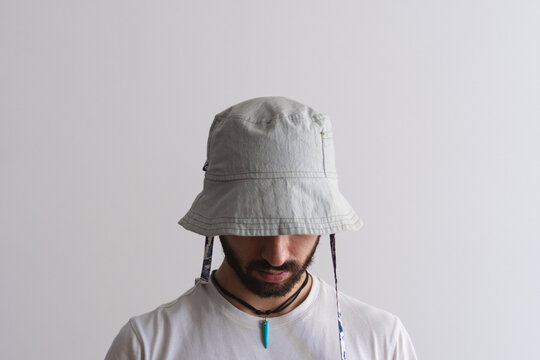 Front view of a young latin man wearing a bucket hat with white background. Product photo.