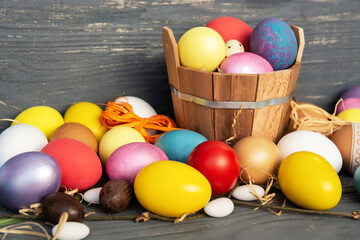 colored Easter eggs and regular egg on wooden holiday banner, background, selective focus image. Happy Easter card