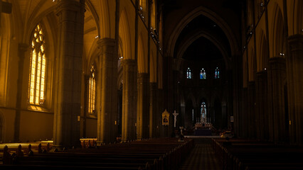Sunlit Interior of a Melbourne Church: Warm Light Illuminating Wooden Benches and Glass Windows