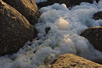 mar con espuma en las rocas de la playa