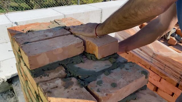 The builder performs bricklaying at the construction site. 4k video footage