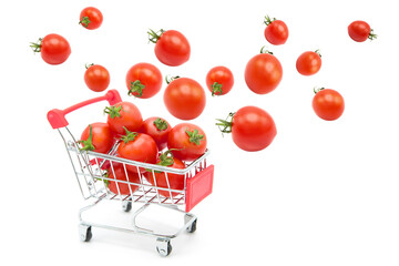 Supermarket shopping cart with ripe fresh tomatoes with tomatoes flying into it isolated on white background. Organic and environmentally friendly vegetables.	