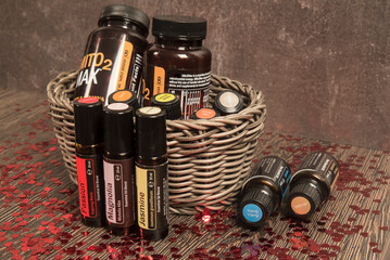 buteleczki z olejkami eterycznymi w wiklinowym koszyku na drewnianym stole z rozsypanymi czerwonymi sercami z okazji walentynek © siwyk