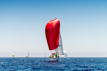Sailboat with red gennaker competing during regatta