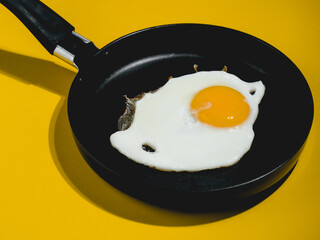fried egg on black pan. top view photography. hen egg, breakfast food, morning meal.Fast healthy food