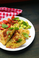 Plate of Italian Frittata or Tortilla de Patatas(Spanish Omelet) with Avocado and Tomato Salad