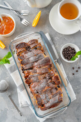 Homemade bread pudding with chocolate chips on a gray concrete background. Selective focus, copy space.