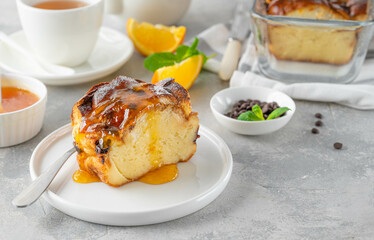 Homemade bread pudding with chocolate chips on a gray concrete background. Selective focus, copy space.
