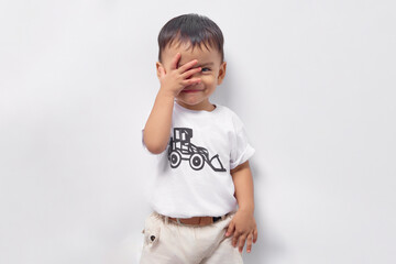 Toddler Asian kid boy 2 years old wearing a white t-shirt covering his face with hand  isolated on white background
