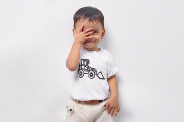 Toddler Asian kid boy 2 years old wearing a white t-shirt covering his face with hand  isolated on...