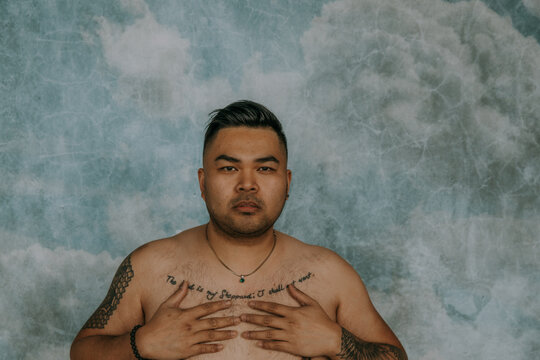Filipino man with hands on chest looking at camera