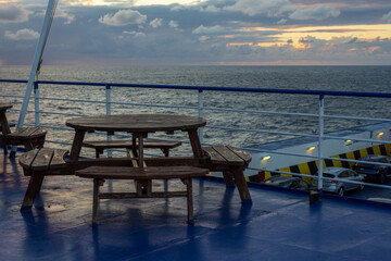 Fototapeta na wymiar tables for resting and eating on the ferry deck at sunrise