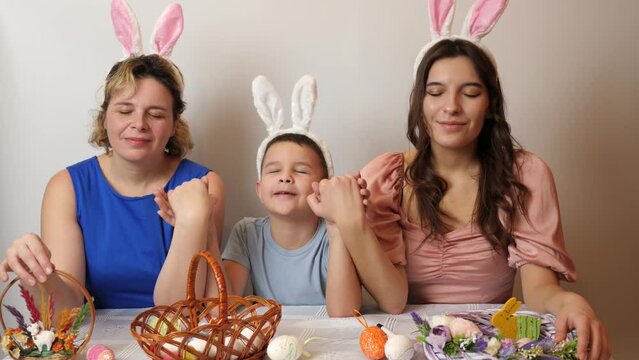 Mother, daughter and son dream, holding hands with closed eyes. Celebrating Easter in the family. Easter games and fun.