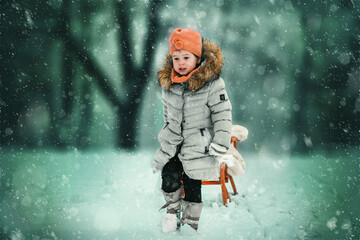 Warm clothing and no winter for me. Warm clothed child pulling sled through snowflakes during the winter snowy day.