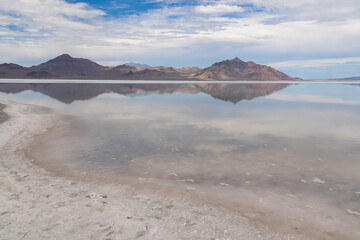 Panoramic view of beautiful mountains reflecting in lake of Bonneville Salt Flats, Wendover, Western Utah, USA, America. Looking at summits of Silver Island Mountain range. West of Great Salt Lake