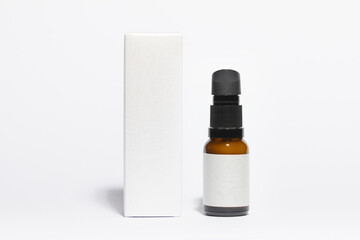 Mockup of packaging box, and amber colored glass bottle of cosmetic and facial skincare products, on a white background