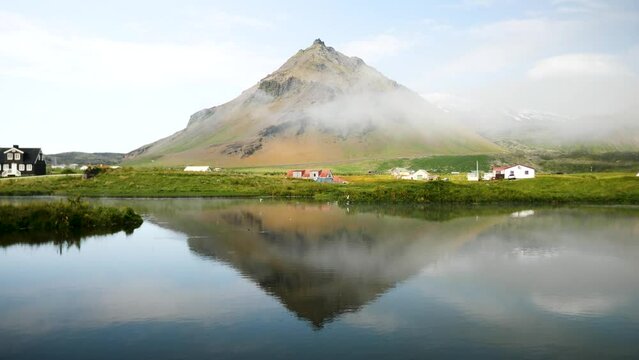 Arnarstapi village in Iceland. Stapafell mountain reflection in the water. Snaefellsjokull in the back. Mountain reflecting in the lake. High quality 4k footage. 