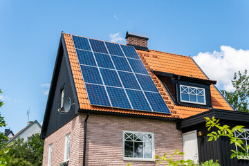 Solar battery panel on a roof of a private house in Europe. Energy-saving technology. Sunny summer day.