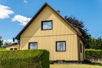 Beautiful vintage yellow wooden private house and blue sky on a sunny summer day