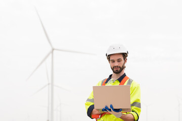 Male engineer working with plan inspecting or maintenance of wind turbines at windmill field farm....