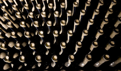 Wine cellar low light interior shot. Wine glass bottle necks with corks backgrounds with a...