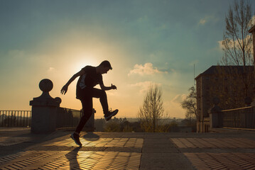 teenager boy with blue hair and sportswear dancing breakdace on the street. hip hop culture. street...