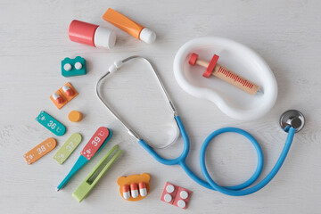 Medical toy plastic instruments on a light table. Doctor's first aid kit. Syringes, pills,...