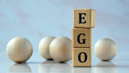 EGO - word on wooden cubes on the background of light balls.