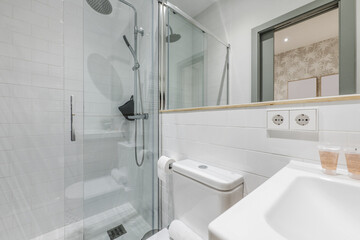 Newly renovated bathroom white porcelain sink, shower cabin with glass screen, mirror integrated...