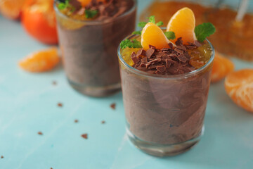 Chocolate mousse dessert with tangerines in glasses