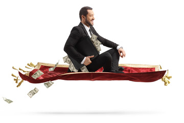 Businessman holding a suitcase with money and sitting on a flying carpet