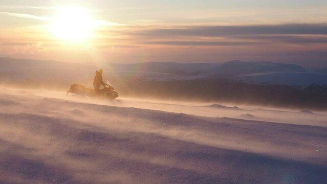 winter sports - exciting snowmobiling tour. winter trips and excursions, severe weather conditions. popular outdoor winter activities, travel in winter. blowing wind and powder snow, wintertime
