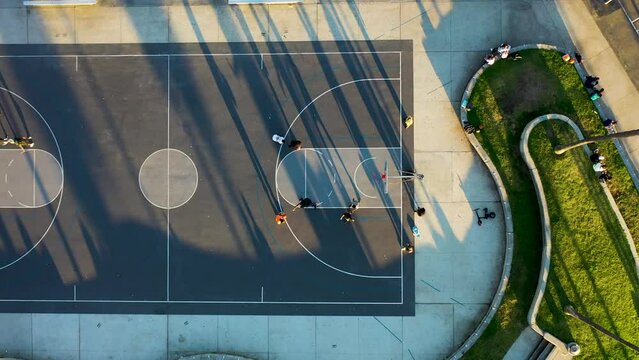 Aerial view of people playing basketball along the beach at sunset, Venice Beach, California, United States.