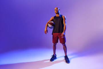 Fototapeta na wymiar Full length portrait of a basketball player with ball on studio background. Advertising concept