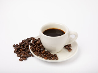 Coffee beans and a cup of stale strong espresso isolated on white background.
