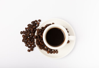 Coffee beans and a cup of stale strong espresso isolated on white background.