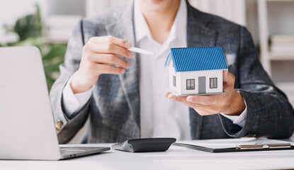 Real estate brokerage agent Deliver a sample of a model house to the customer, mortgage loan agreement Making lease and buying a house And contract home insurance concept