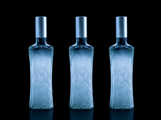 Frozen bottle of vodka covered with frost, close-up isolated on black