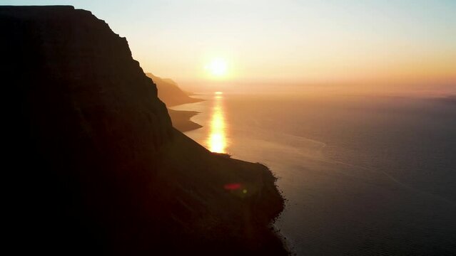 Aerial view of beautiful coastline with high cliffs at sunset facing the ocean at Tungurif Golden beach, Westfjord, Iceland.