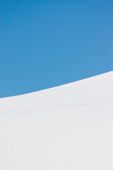 Abstract curve between white snows and blue sky in winter