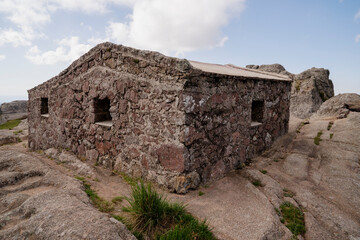 View of a mountain refuge built with stone at the top of the hill. 