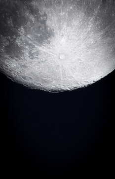 Looking Up. Awe inspiring vertical photo of the Tycho Crater and various other meteor craters on the moon. Set against a black sky background with copy space.