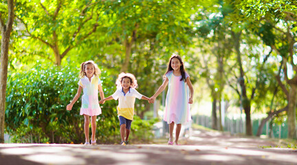 Happy kids play in summer park.