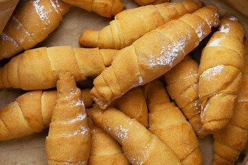 Fresh Baked Croissants or bagels. A pile of tasty crispy croissant on a wooden table. traditional homemade french pastries