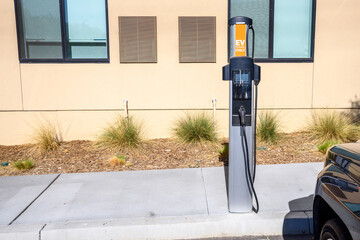 Recharging point for electric vehicle in a parking lot at the back of a building