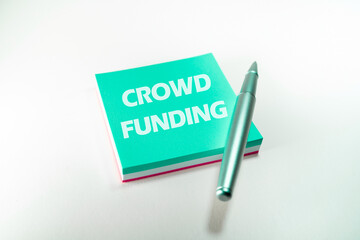 Crowd funding concept. Crowd funding word writed in a blue post it. Charity, fundraising, investment and financial concept. Crowdsurcing management concept.