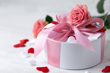 Beautiful surprise greeting for saint Valentine's or Women's Day, birthday or Anniversary for beloved. Fresh pink roses, gift box with sweets. White background. Holiday atmosphere